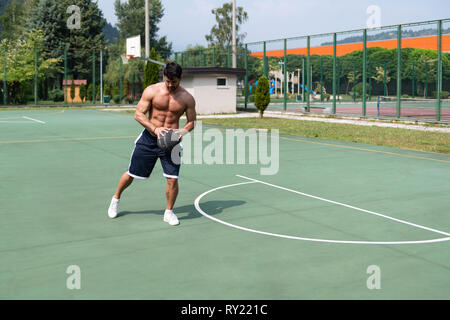 Basketball Player Bodybuilder Practicing And Posing For Basketball And Sports Athlete Concept Stock Photo