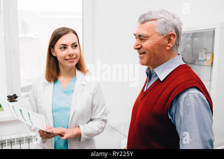 doctor discussing medical record with senior patient at medical room Stock Photo