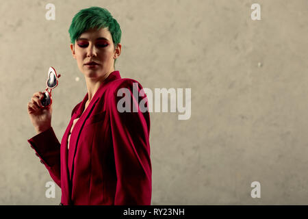 Serious nice green haired woman looking down Stock Photo