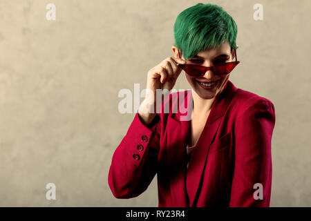Delighted positive young woman fixing her glasses Stock Photo