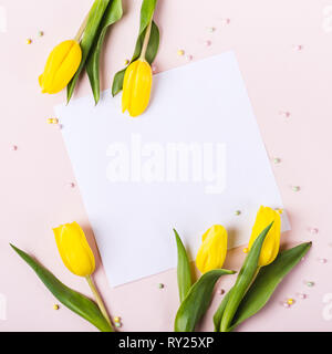 Beautiful yellow tulip flowers on pastel pink background for words of congratulations. Stock Photo
