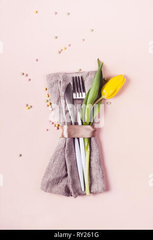 Beautiful table setting with pink tulip flower on light blue background ...