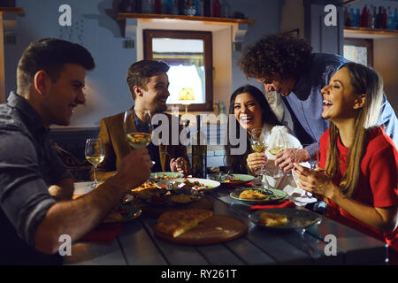 Young people meeting friends for dinner in a restaurant Stock Photo