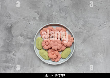 Flower cookies on a plate on a gray background . Spring holidays cooking concept. Top view, flat lay, copy space. Stock Photo
