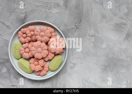 Flower cookies on a plate on a gray background . Spring holidays cooking concept. Top view, flat lay, copy space. Stock Photo