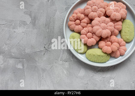 Flower cookies on a plate on a gray background . Spring holidays cooking concept. Top view, flat lay, copy space. Stock Photo