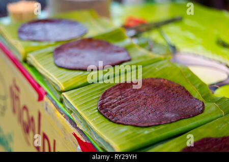 Fresh prepared asian black sticky rice pancake on banan leaf. Traditional thai cuisine made of fresh ingredients. Stock Photo