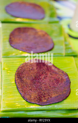 Fresh prepared asian black sticky rice pancake on banan leaf. Traditional thai cuisine made of fresh ingredients. Stock Photo