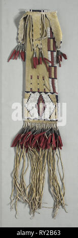 Pipe Bag, c. 1870. America, Native North American, Plains, Tsitsistas (Cheyenne) people, Post-Contact. Native-tanned hide with yellow pigment, glass beads, red trade cloth, tin cones, sinew thread; overall: 71.1 x 12.7 cm (28 x 5 in Stock Photo