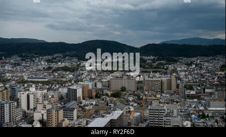 Aerial shots of the city of Kyoto. Skyscrapers and buildings expand out into the distance of the Japanese city as a stormy sky and clouds . Stock Photo