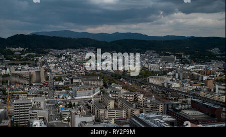 Aerial shots of the city of Kyoto. Skyscrapers and buildings expand out into the distance of the Japanese city as a stormy sky and clouds . Stock Photo