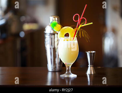 Pina Colada. Yellow alcohol cocktail with pineapple, lemon, cold vodka filled with crushed ice in a beautiful cocktails glass on a bar background Stock Photo