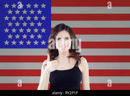 Portrait of happy american girl with thumb up against the USA flag background. Travel and learn english language concept Stock Photo