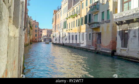 A cruising white speedboat on the grand canal with the view of the bridge and the buildings on the sidein Venice Italy Stock Photo
