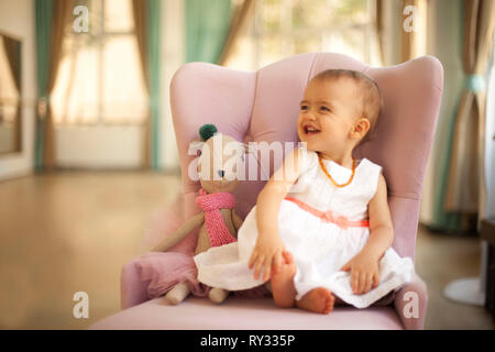Cute adorable baby girl playing with first doll Stock Photo