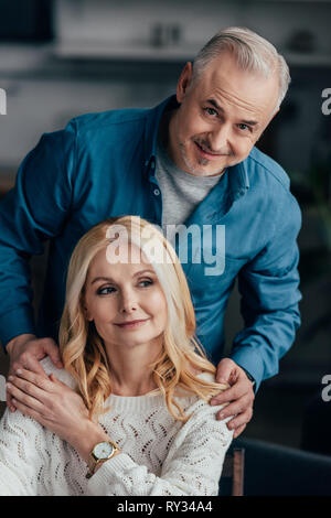 handsome man embracing cheerful wife at home Stock Photo