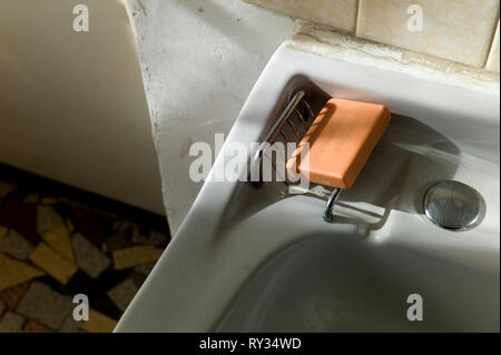 New bar of soap in old bathroom in sunlight Stock Photo