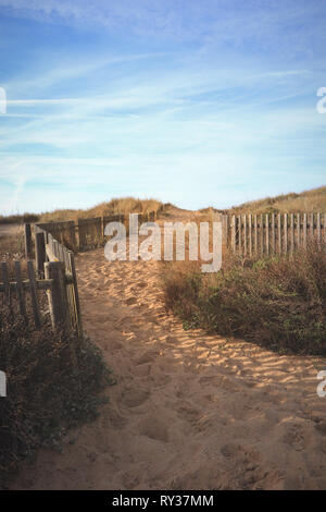 Path to the beach through the dunes surrounded by a wood fence Stock Photo