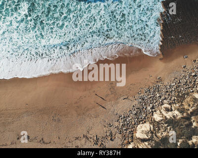 Aerial view from a couple walking in a sandy beach. Drone photo Stock Photo