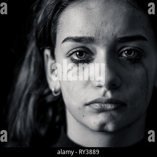 Scared upset girl bullied online suffering harassment crying feeling desperate and intimidated. Child victim of cyberbullying, stalker, social media a Stock Photo