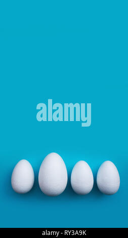 White foam eggs on blue background. Flat lay, top view. Easter concept. Stock Photo