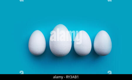 White foam eggs on blue background. Flat lay, top view. Easter concept. Stock Photo
