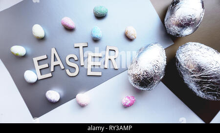 Eggs in foil on silver background. Easter concept banner. With text Easter