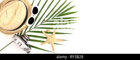Summer traveler accessories retro camera, straw hat, sunglasses, seashells, starfish and tropical palm leaf on white background. Travel or vacation concept. Flat lay, top view. Summer background. Stock Photo