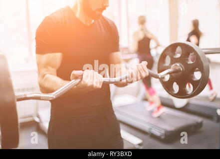 Muscular Bearded man during workout in the gym. Stock Photo