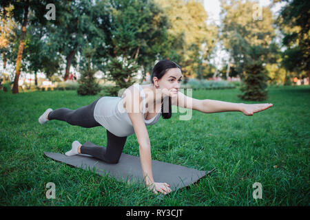 Concentrated fit female stretching legs and doing lunge exercises on pilates  reformer during training in gym stock photo