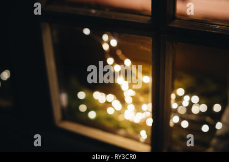 Light decorations during Christmas holiday season on windows - defocused view of lights with bokeh Stock Photo