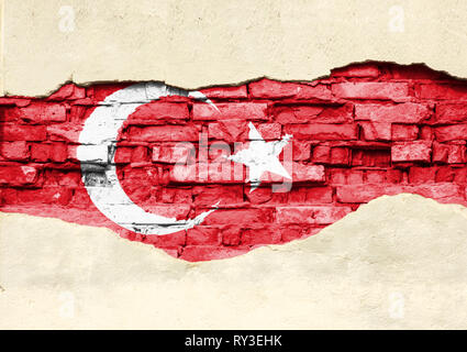 National flag of Turkey on a brick background. Brick wall with partially destroyed plaster, background or texture. Stock Photo