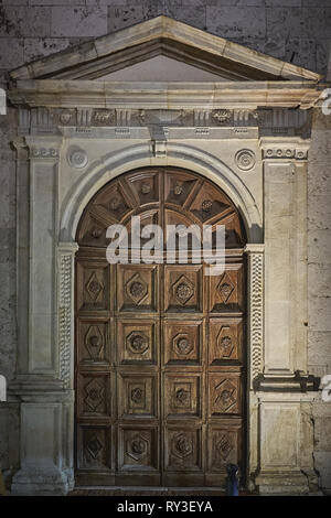 Decorated carved wooden door of the San Francesco church in Montefalco, Umbria (Italy). Portrait format. Stock Photo