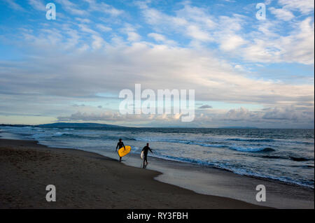 Surfers on Santa Monica Beach with Palos Verdes Peninsula in background in Los Angeles, CA. Stock Photo