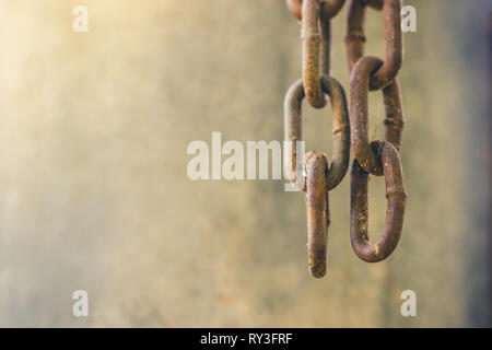 Two old rusty chains were hanging down from above, Beside the wall, Copy space on cement background. Stock Photo