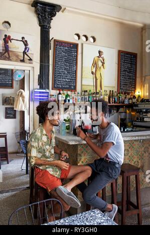 Cuba, La Havana, old Habana, listed as World Heritage by UNESCO, young trendy men sitting in the Dandy bar Stock Photo