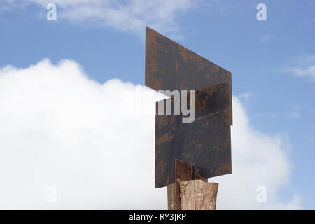 Blank guide post made of steel plates are pinned on wooden posts on sky background. Stock Photo
