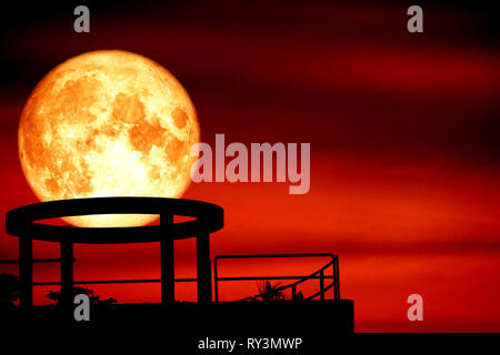 blood moon back over silhouette cycle on roof of building and night red sky cloud, Elements of this image furnished by NASA Stock Photo