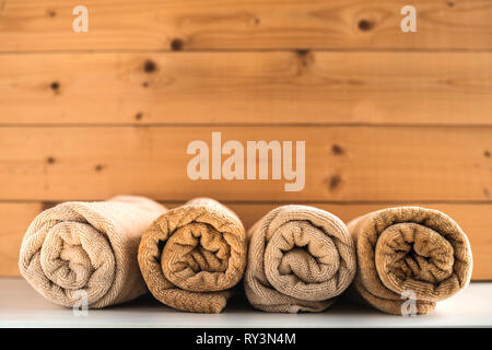 Rolled up bath towels on wooden background. Stock Photo