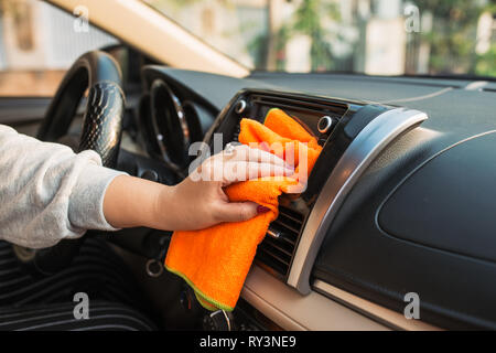 Hand with microfiber cloth cleaning seat, auto detailing and valeting concept, washing car care interior, selective focus Stock Photo
