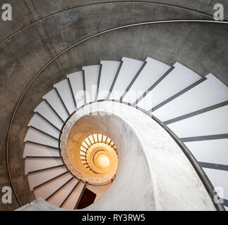 Empty interior spiral modern concrete stair leading to a basement Stock Photo
