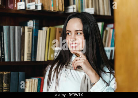 Thoughtful girl chooses books for the exam Stock Photo