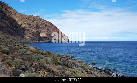 Solitary landscape of the wild south coast of the island of El Hierro, with endemic tropical flora growing on the rocky soil, abrupt volcanic cliffs Stock Photo