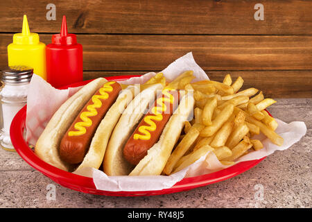 Duo of hot dogs and french fries on table. Fast food restaurant concept. Close up. Copy space for your text. Stock Photo