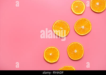 Orange slices on a pink background. fresh orange slices fruit pattern on pink background. Stock Photo