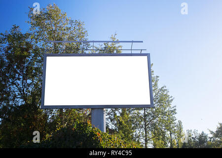 Blank billboard in a green scenery with a bright blue sky Stock Photo