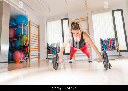 Middle-aged woman (40-45 years old) practicing fitness in a gym. Stock Photo