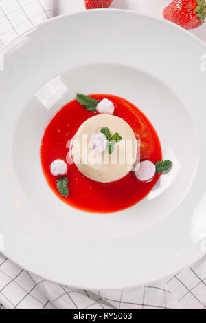 White souffle served with strawberry sauce and mint leaves in white plate Stock Photo