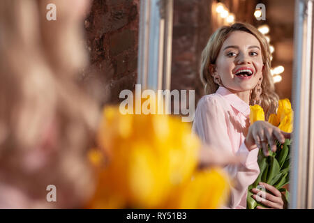 Stylish beaming blonde woman feeling happy after romantic date Stock Photo