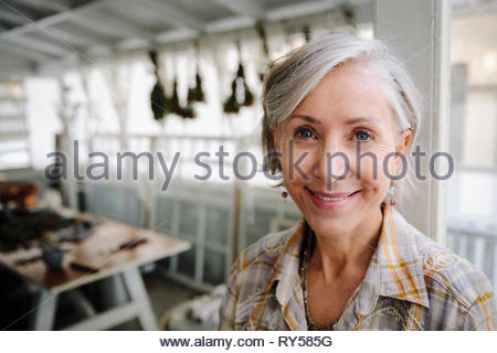 Portrait smiling, confident senior woman in workshop